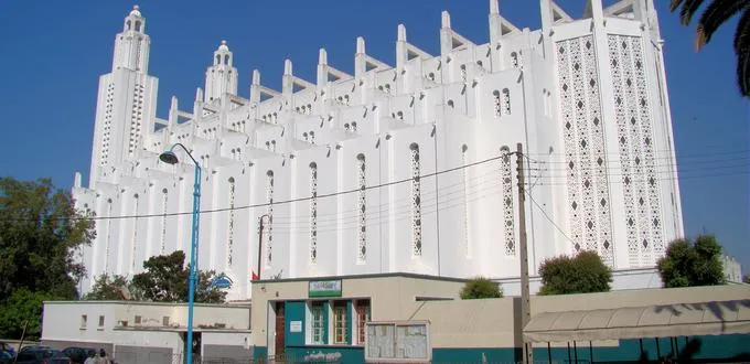 The Sacred Heart Cathedral in Casablanca, a historic gem to visit in Casablanca, showcasing a white Art Deco structure with two towers and geometric patterns under a clear blue sky, a notable Casablanca attraction.